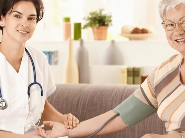 Ápoló vérnyomást mér egy idős hölgynek otthoni környezetben